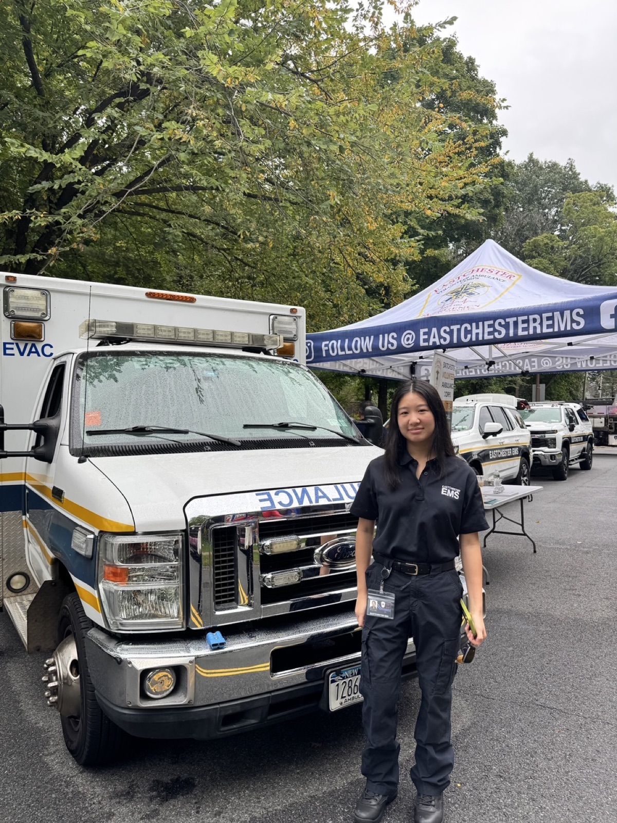 Rachel beside an EVAC ambulance at a community event